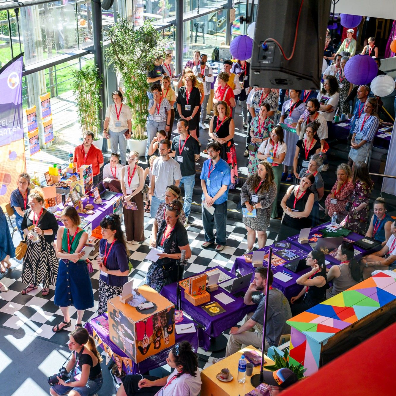 Groep mensen in de foyer van Factorium luisteren naar een presentatie.
